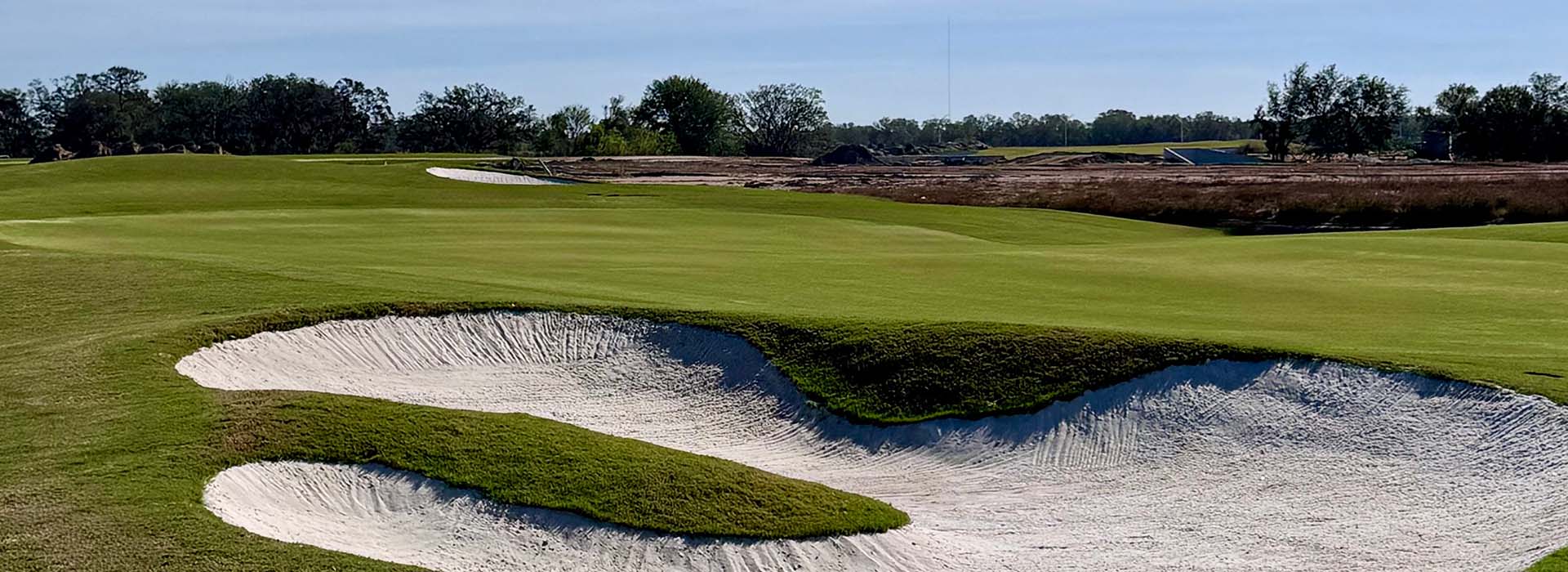 Picture of a sand pit at the course on a sunny day.